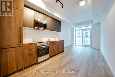 A modern kitchen with wooden cabinets and stainless steel appliances.