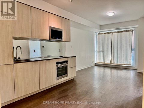 A kitchen with wooden cabinets and a microwave above the stove.