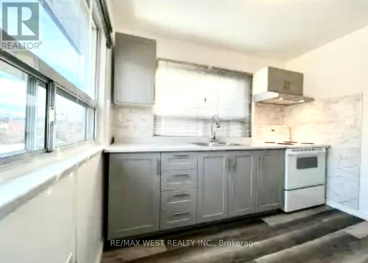 A kitchen with a white oven and grey cabinets.