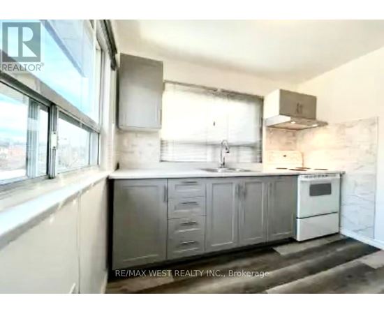 A kitchen with a white oven and grey cabinets.