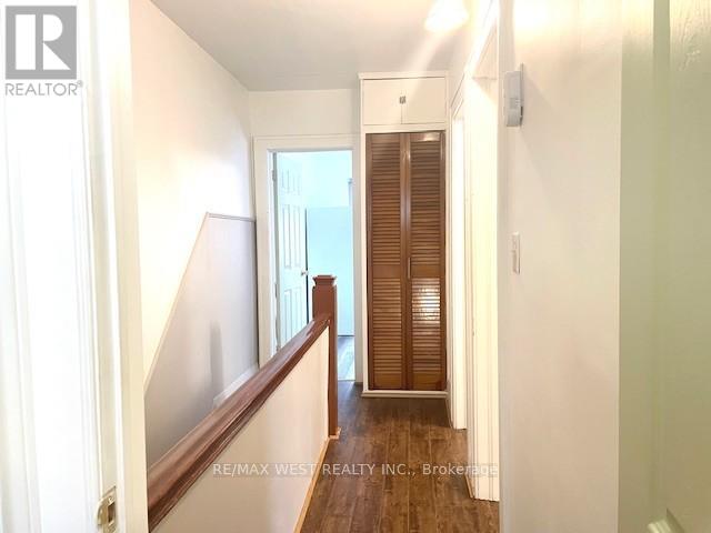 A hallway with a wooden floor and white walls.