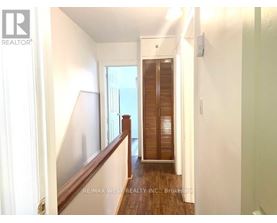 A hallway with a wooden floor and white walls.