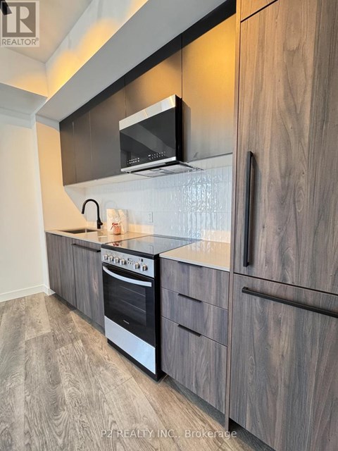 A modern kitchen with a stainless steel oven and microwave.