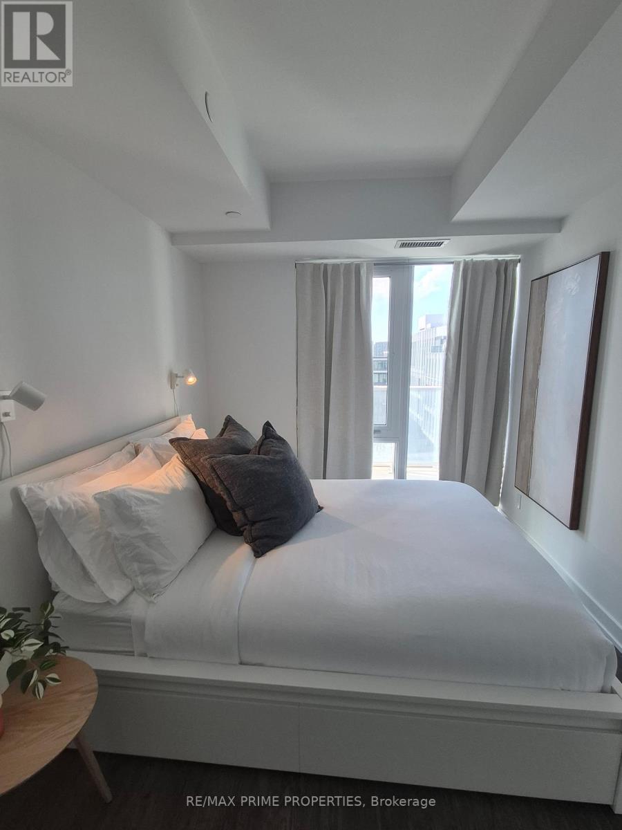 A bedroom with a bed, pillows, and a small table.