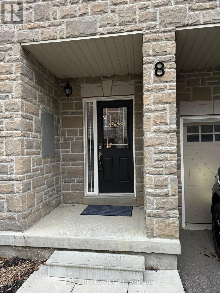 A black door with a glass window is on a stone building.