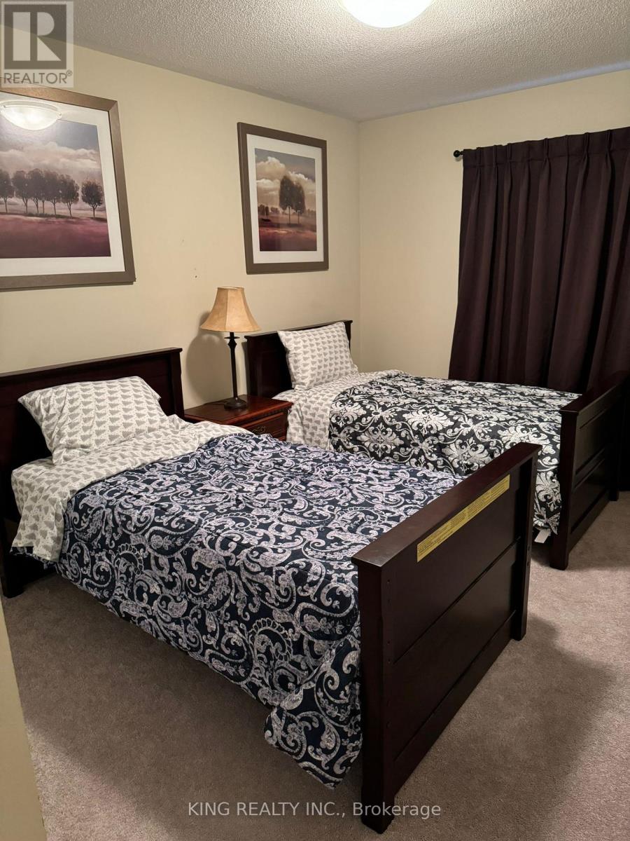 A bedroom with two beds and a lamp.