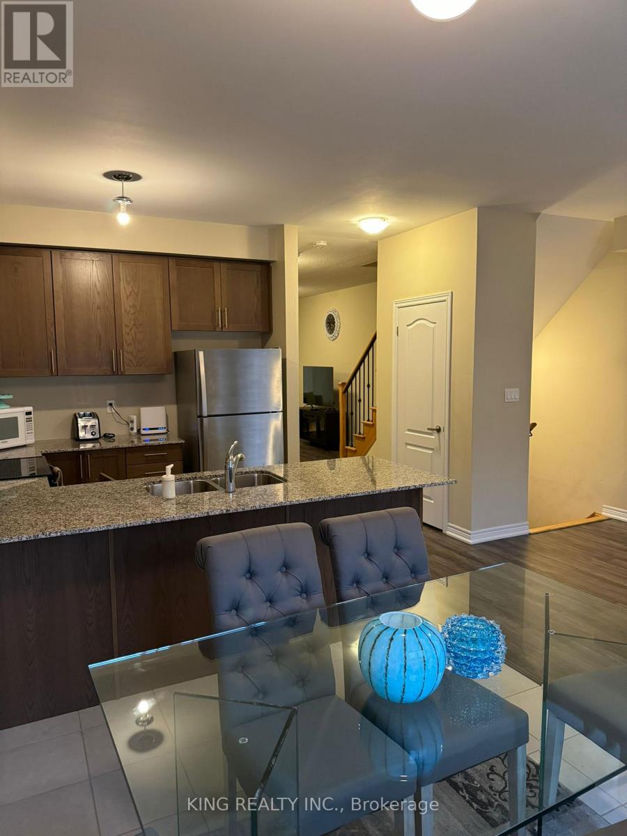 A modern kitchen with a glass table and a blue vase.