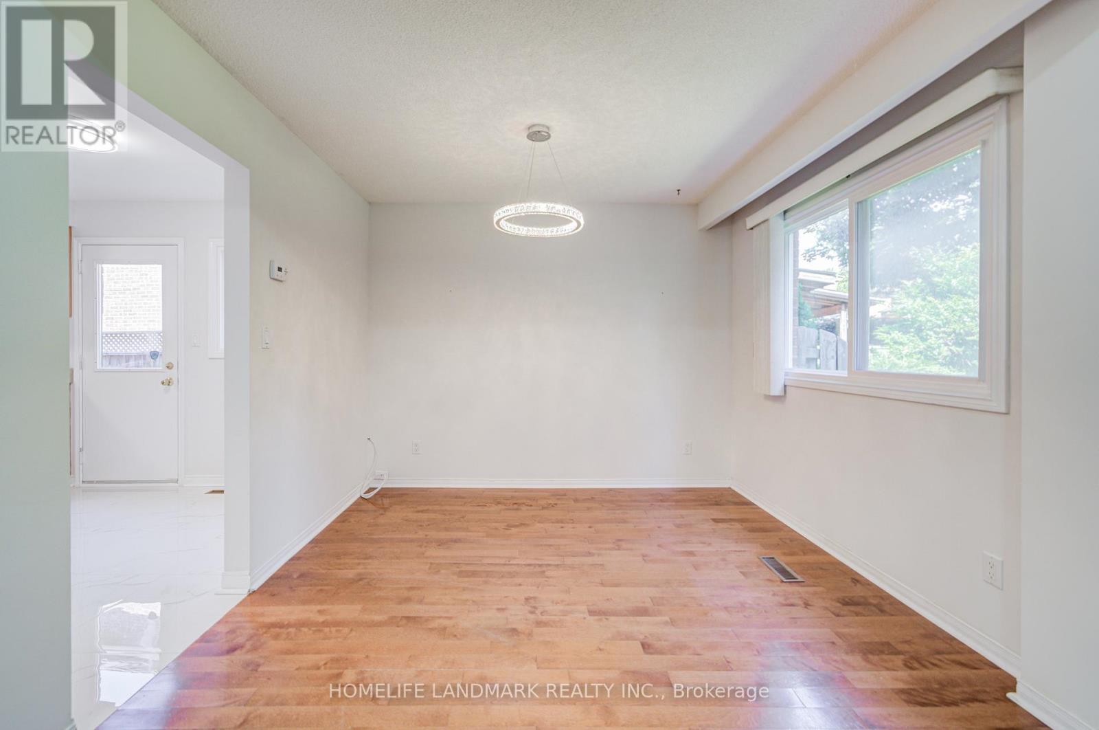 A room with wooden flooring and white walls.