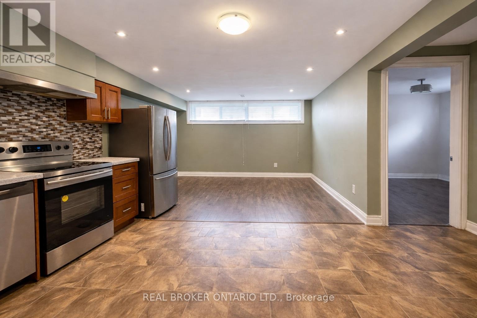 A kitchen with a stove top oven and a refrigerator.