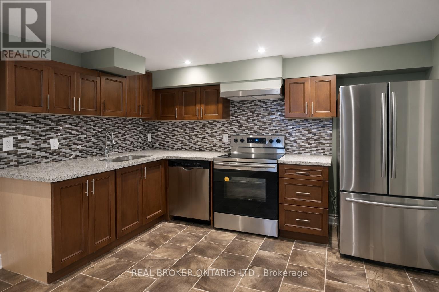 A kitchen with a stove top oven and a refrigerator.