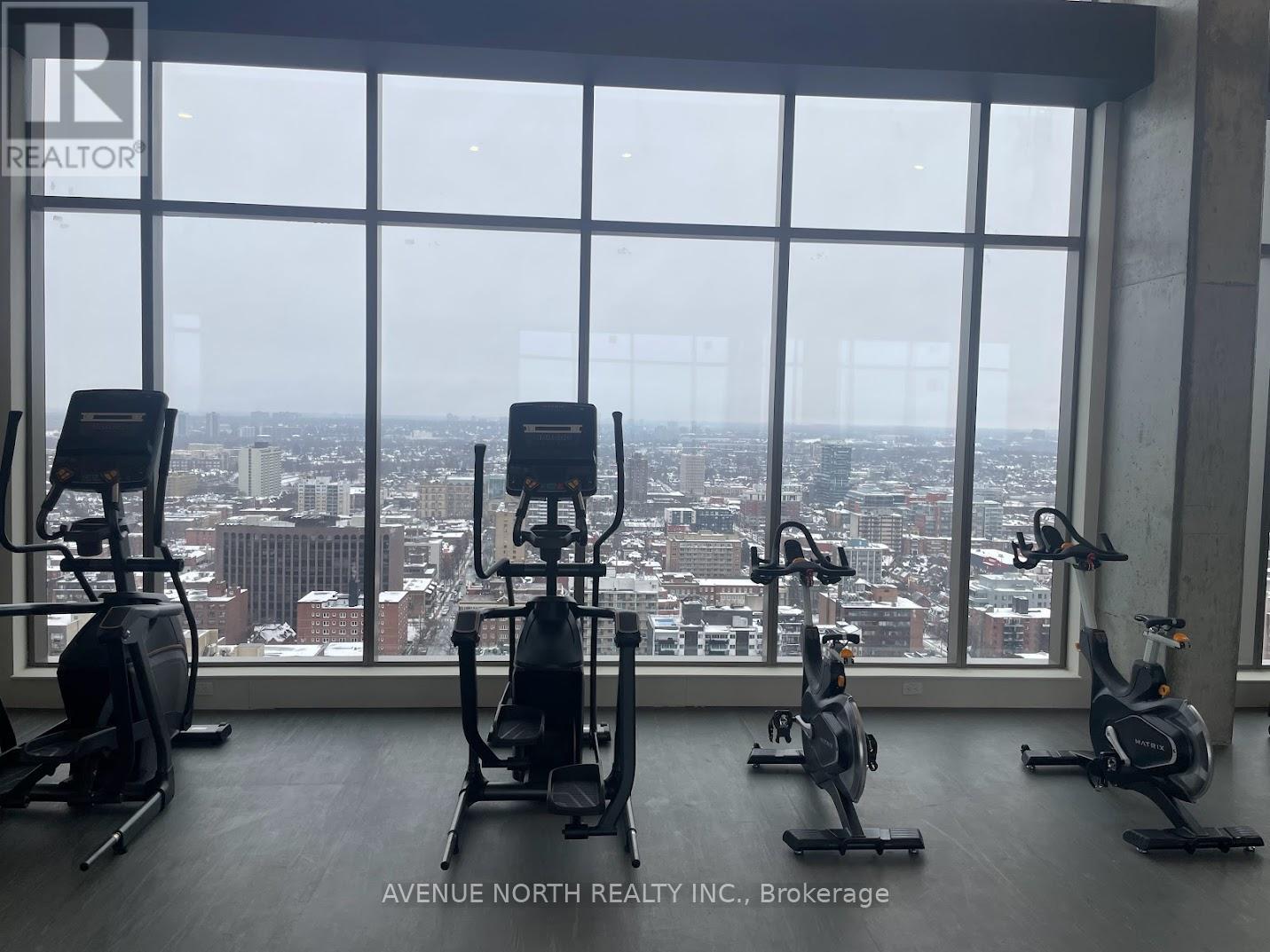 A gym with exercise equipment and a view of the city.