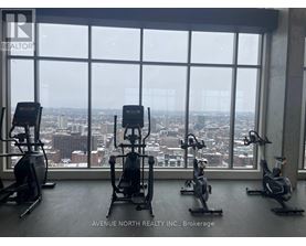 A gym with exercise equipment and a view of the city.