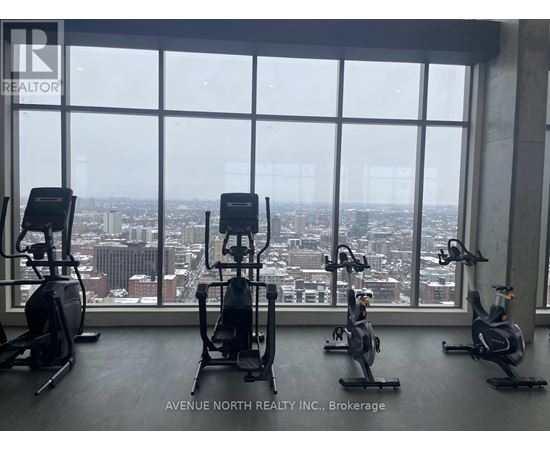 A gym with exercise equipment and a view of the city.