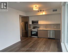 A kitchen with wooden floors and stainless steel appliances.
