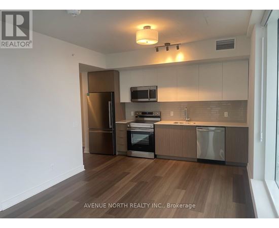 A kitchen with wooden floors and stainless steel appliances.