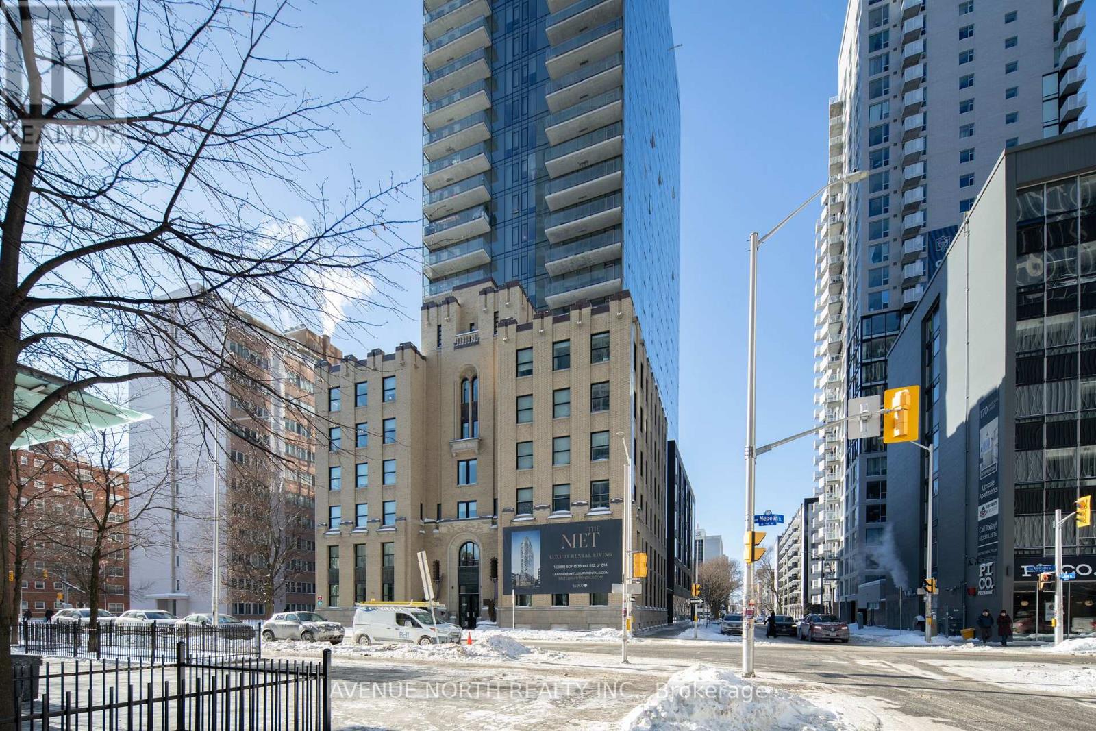 A city street with a large building under construction in the middle.