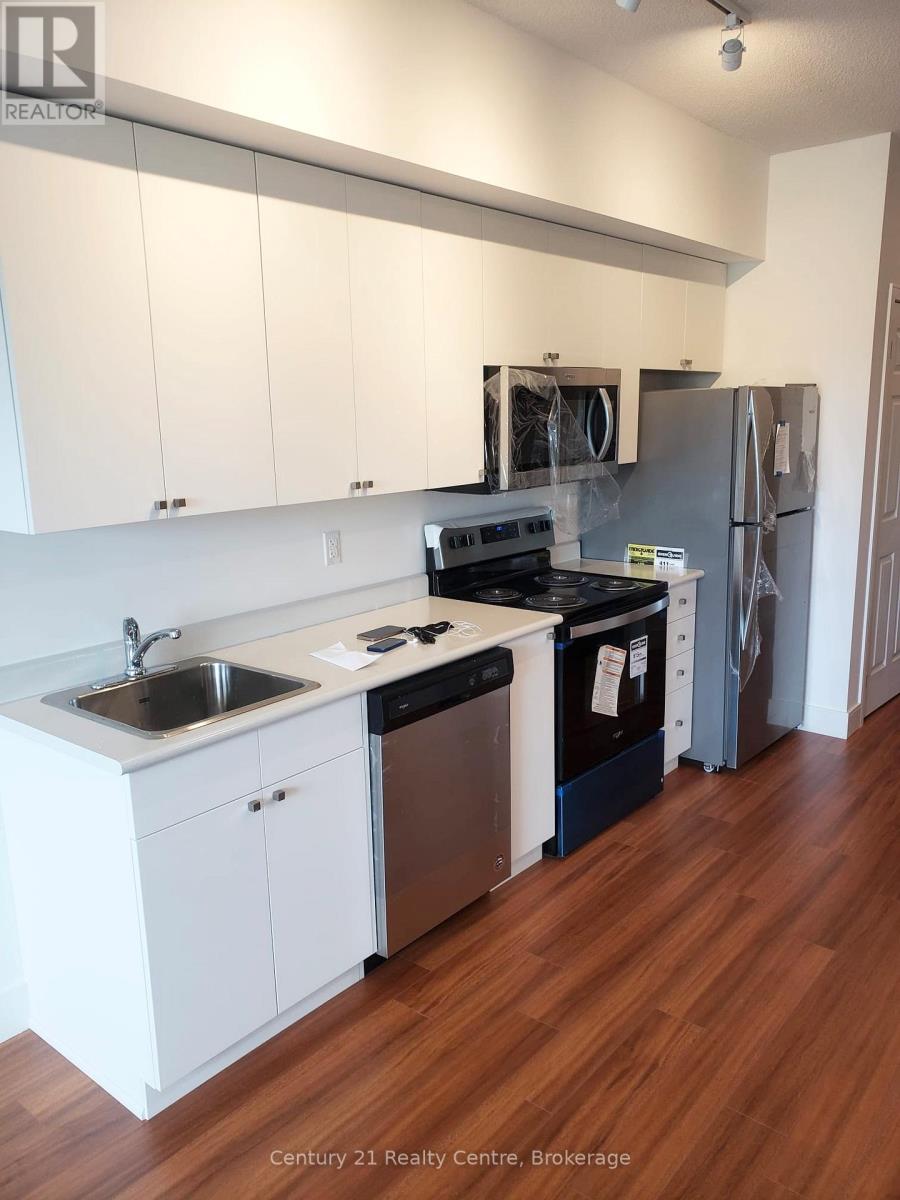 A kitchen with white cabinets and a wooden floor.