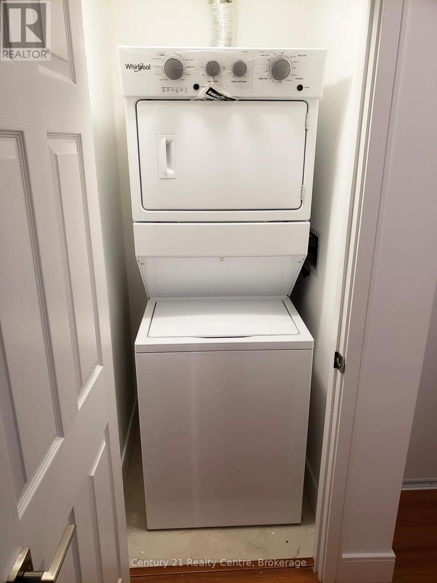 A white Whirlpool washing machine and dryer in a small laundry room.
