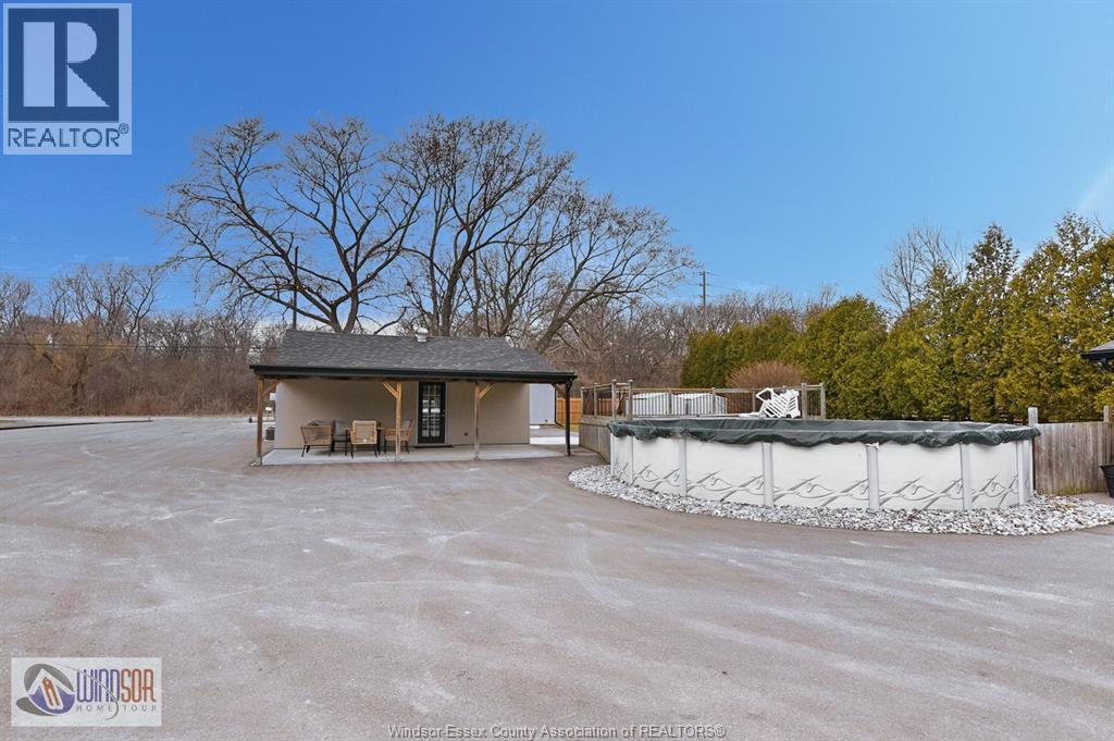 A realtor photo of a house with a pool in the backyard.