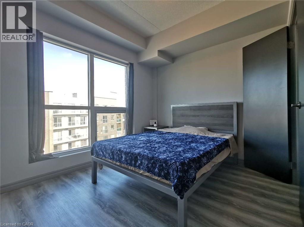 A bedroom with a bed, dresser, and window.