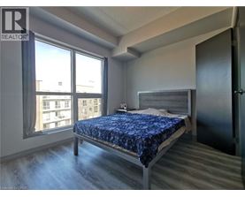 A bedroom with a bed, dresser, and window.