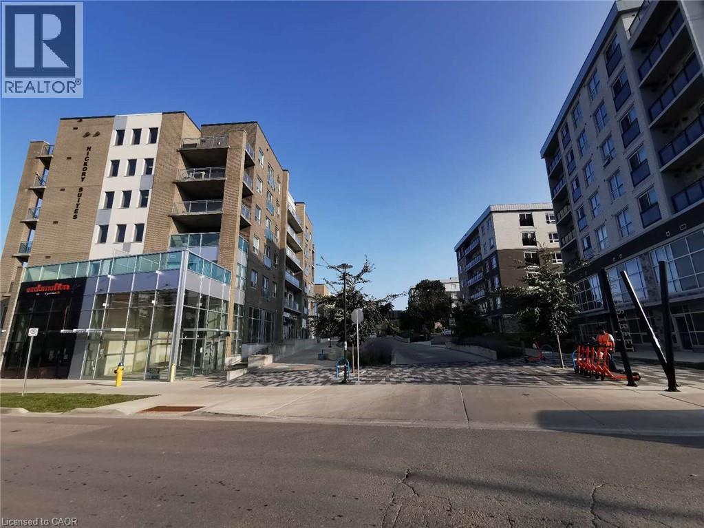 A modern apartment building with a glass entrance and a clear blue sky.