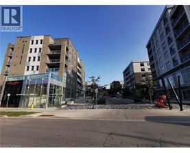 A modern apartment building with a glass entrance and a clear blue sky.