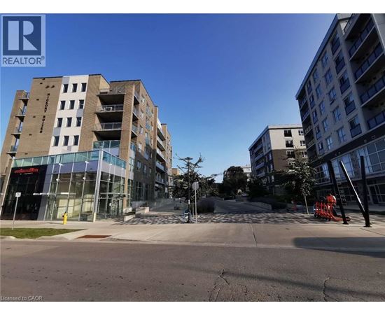 A modern apartment building with a glass entrance and a clear blue sky.