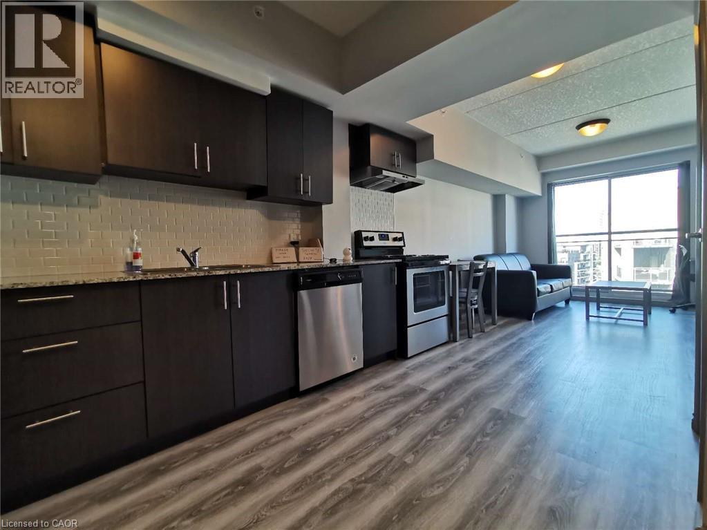 A kitchen with dark wood cabinets and a stainless steel dishwasher.