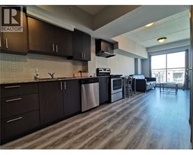 A kitchen with dark wood cabinets and a stainless steel dishwasher.