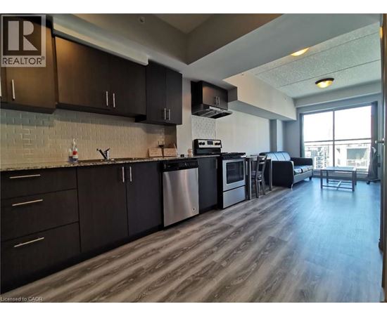 A kitchen with dark wood cabinets and a stainless steel dishwasher.