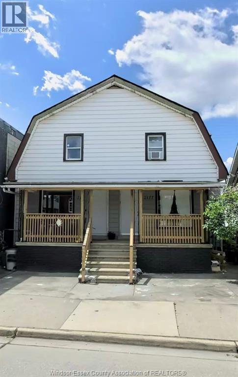 A two-story house with a porch and a front door.