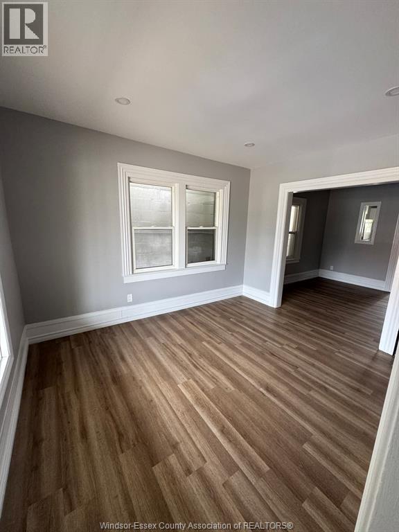 A room with wooden flooring and a window.