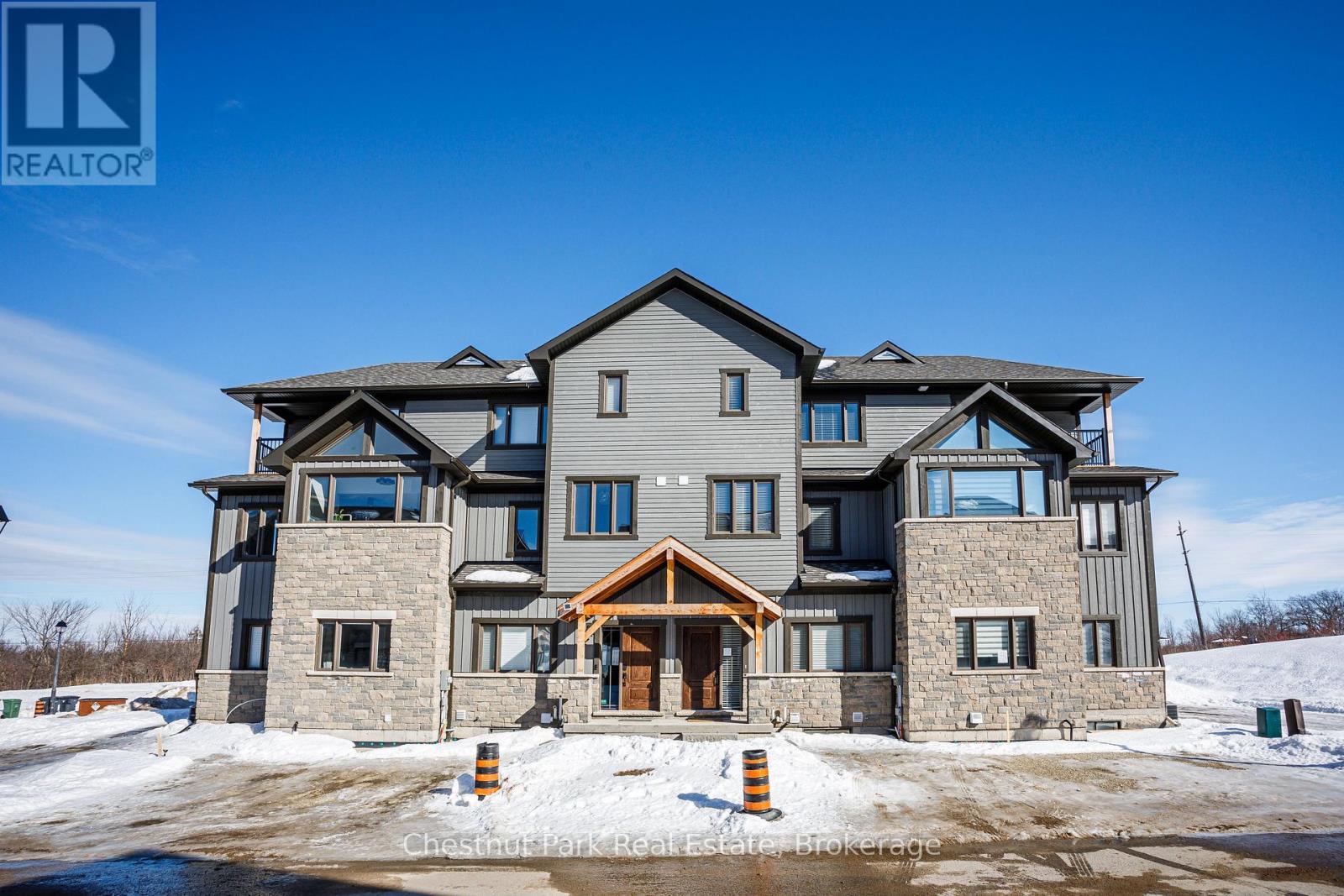 A large, modern house with a stone facade and a large front porch.