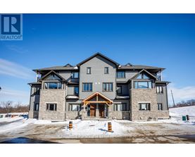 A large, modern house with a stone facade and a large front porch.