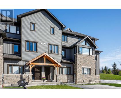 A large, modern house with a stone facade and a large front porch.
