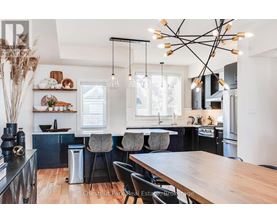 A modern kitchen with a wooden table and black chairs.