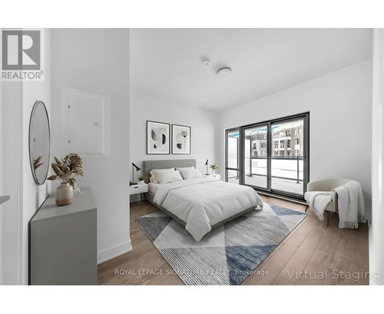A bedroom with a large bed, a chair, and a window with a view of a building.