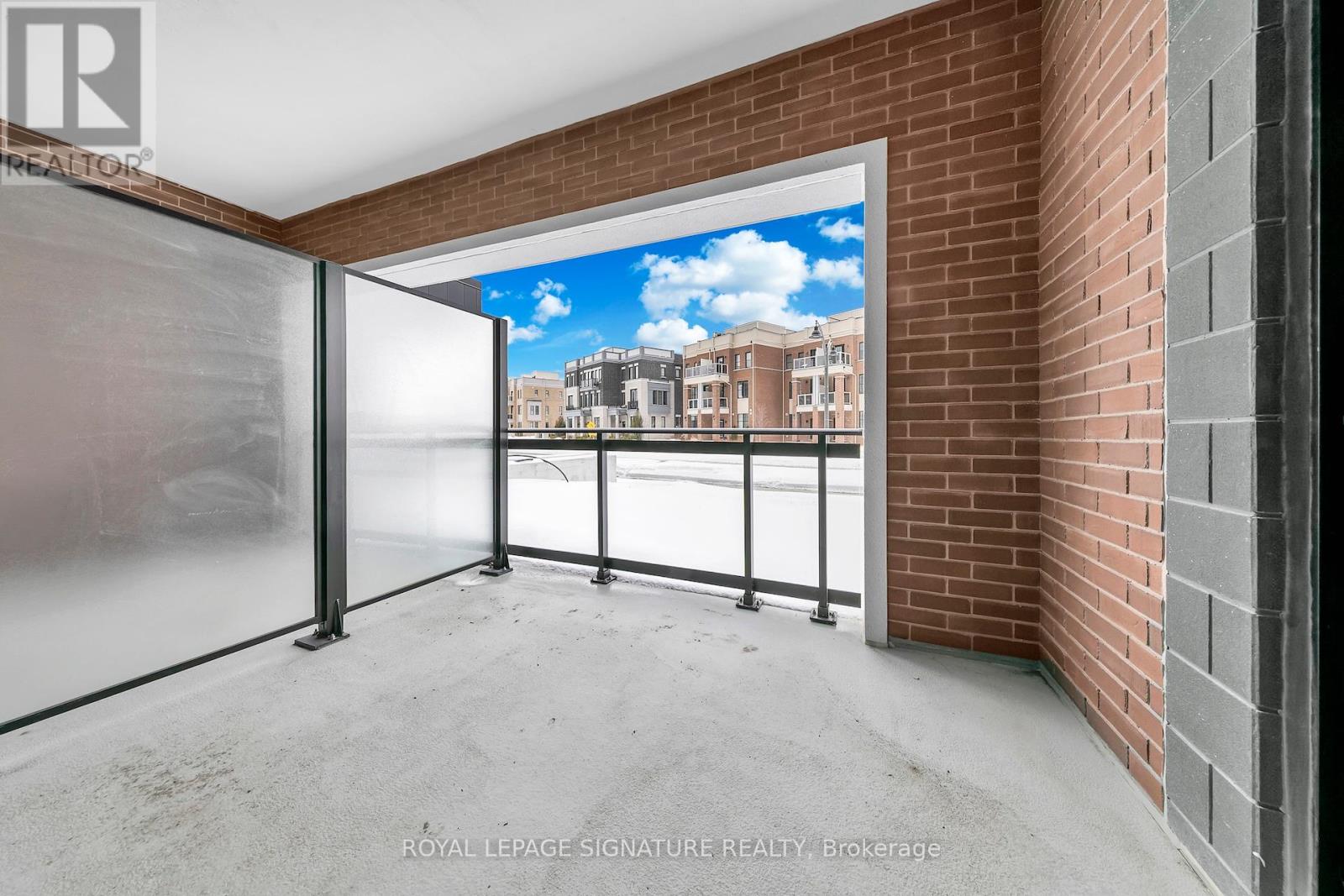 A room with a glass door leading to a balcony with a view of a building.