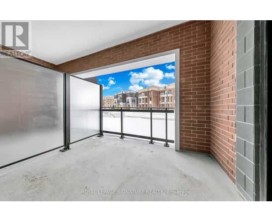 A room with a glass door leading to a balcony with a view of a building.