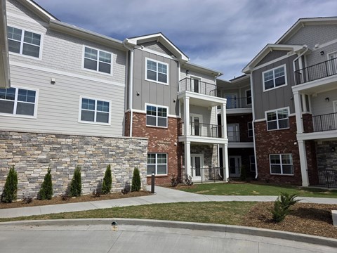 Apartment complex with a mix of stone and brick buildings.