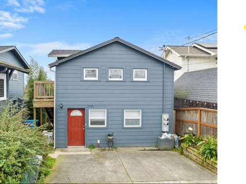 A blue house with a red door and a garage.