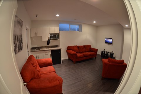 A living room with a red couch and a television.