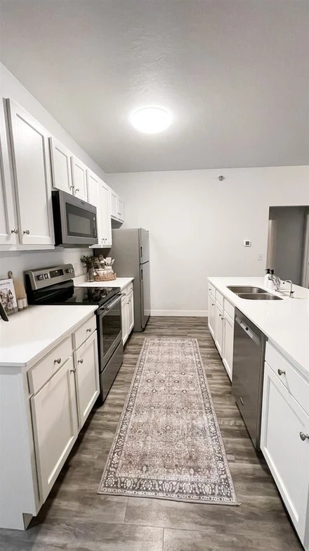 A kitchen with white cabinets and a rug on the floor.