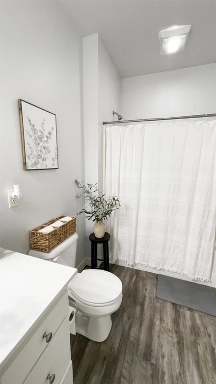 A white toilet sits next to a white sink in a bathroom.