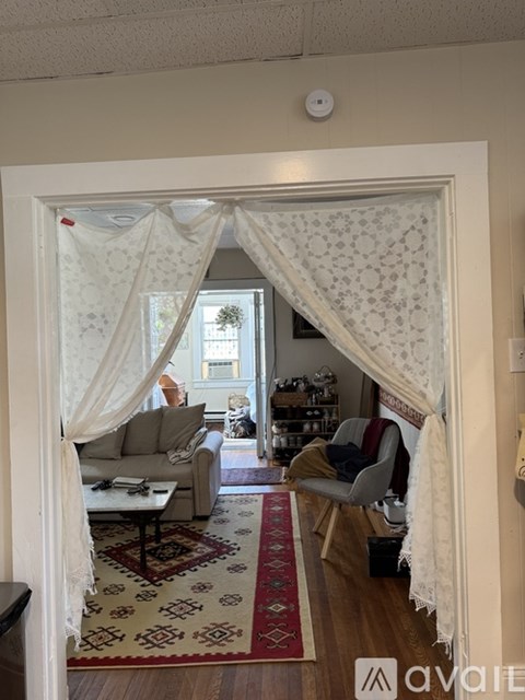 A living room with a couch, chairs, and a rug.