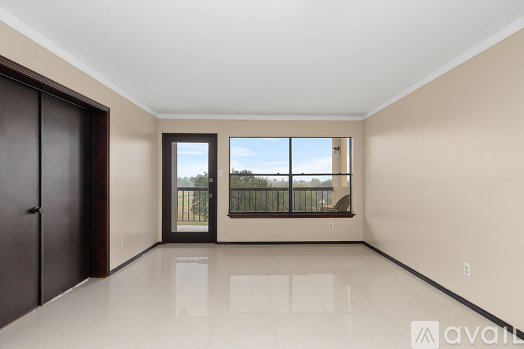 A spacious room with a large window and a balcony.