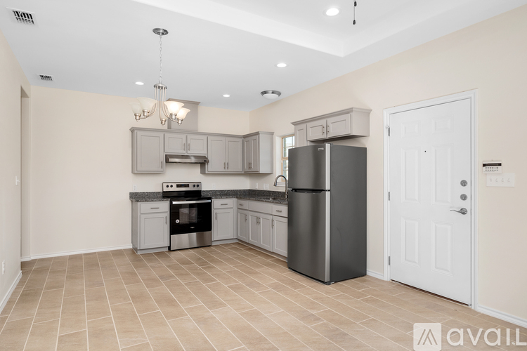 A kitchen with a refrigerator, oven, and cabinets.