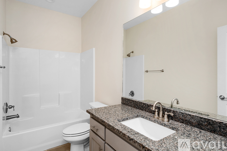 A bathroom with a toilet, sink, and mirror.