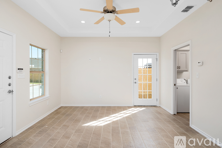 A spacious room with a ceiling fan and tiled flooring.